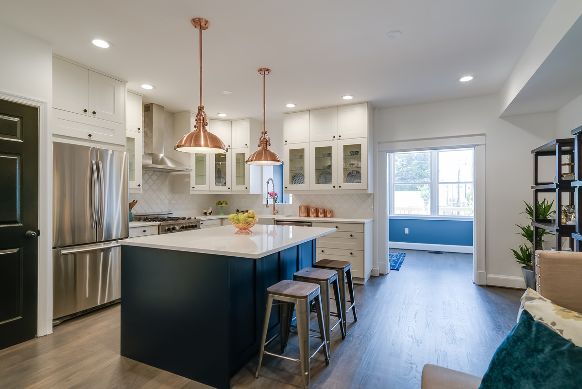 San Diego kitchen remodel with navy island, copper pendant lights, white shaker cabinets, and modern open layout by Honeycomb Design Build